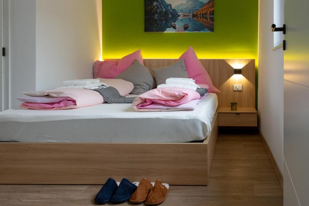 a bedroom with a bed with pink pillows and shoes at Luani appartments in Krefeld