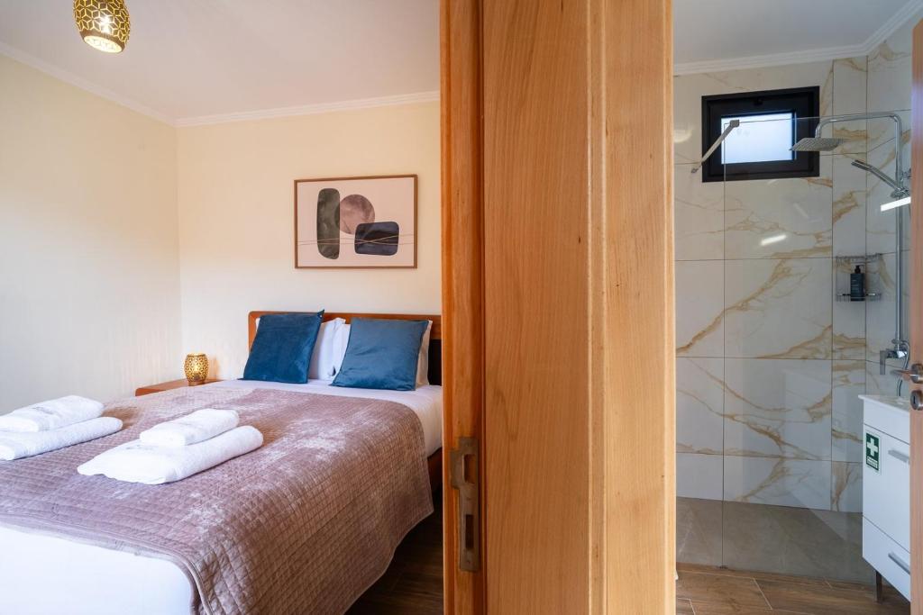 a bedroom with a bed and a shower at GuestReady - Casa do Feno in Santa Cruz