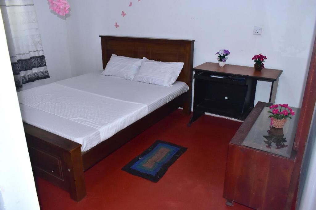 a bedroom with a bed and a nightstand and a bed sidx sidx sidx sidx at Upali Homestay in Kandy
