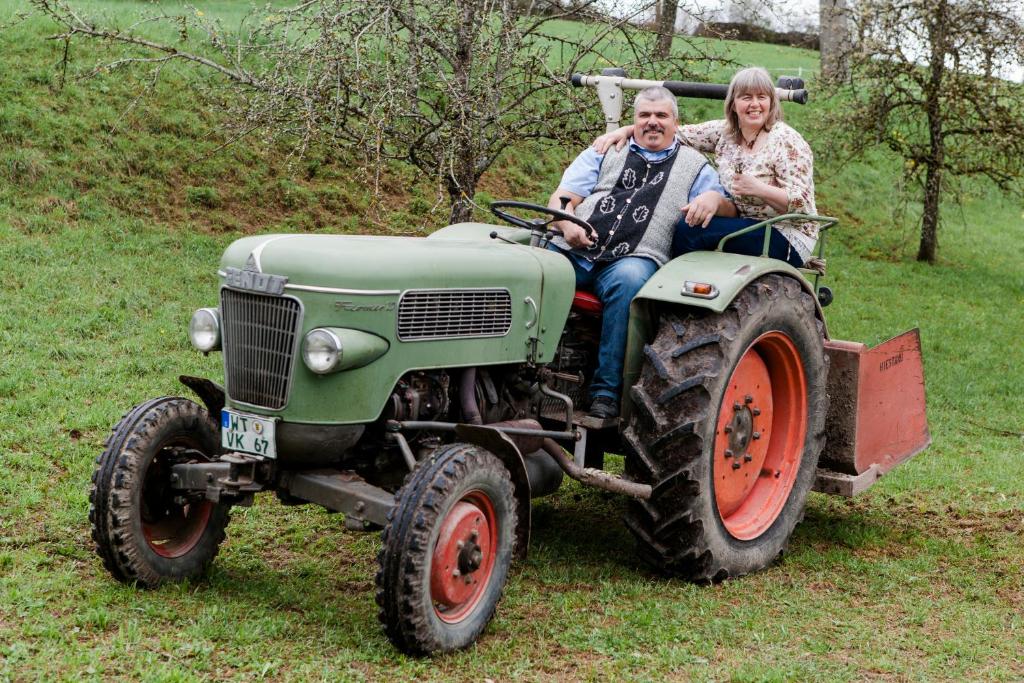 un hombre y una mujer sentados en un tractor en Ferienhaus Aschoff, en Mauchen