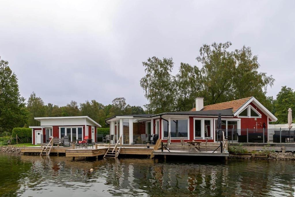 a couple of houses on a dock on the water at OGO827-Vreta-Kloster-Sjoebacka-17 in Vreta Kloster