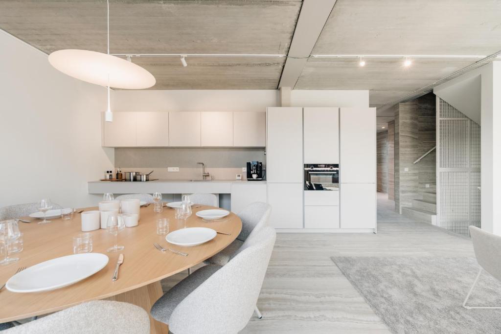 a kitchen and dining room with a wooden table and chairs at Coliving - Bord de Meuse - L'instant in Oupeye