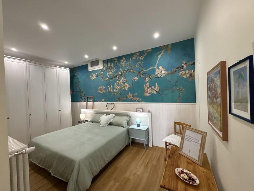 a bedroom with a bed and a painting on the wall at Le Jardin Fleuri in Castelluccio Valmaggiore
