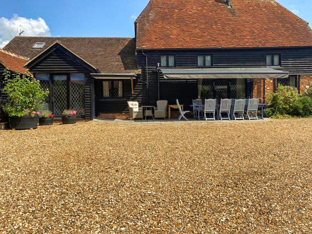 a house with chairs and a patio in front of it at Rumbolds Retreat in Plaistow