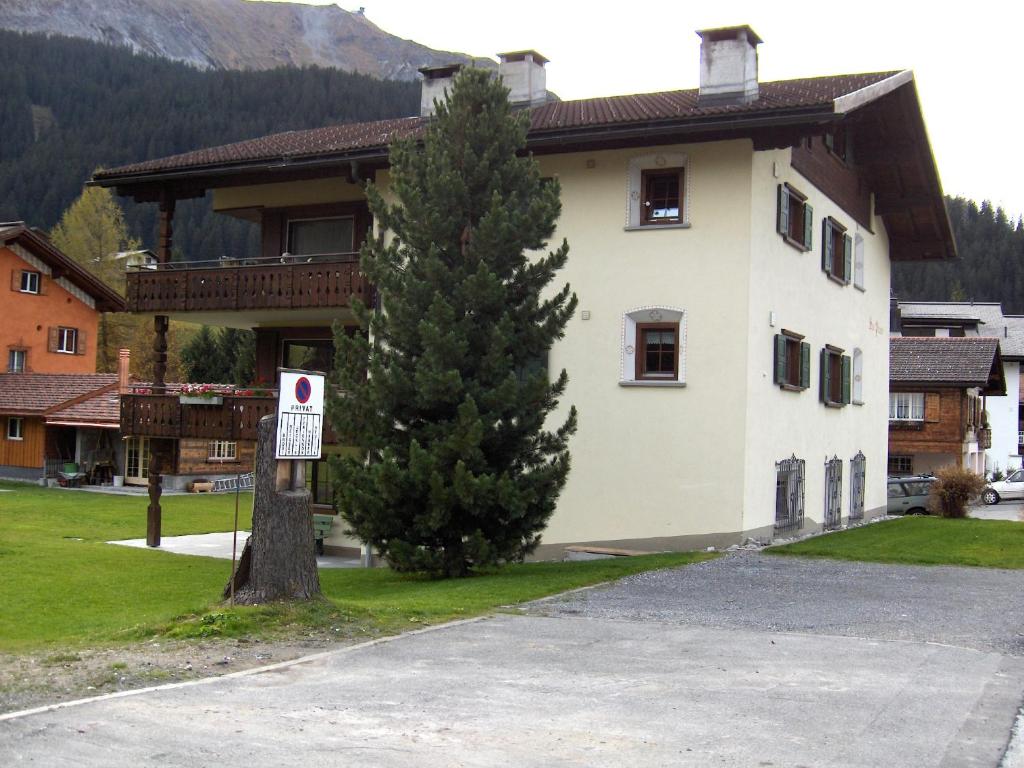 un arbre devant un bâtiment sans panneau de stationnement dans l'établissement Hus Pravis, à Klosters