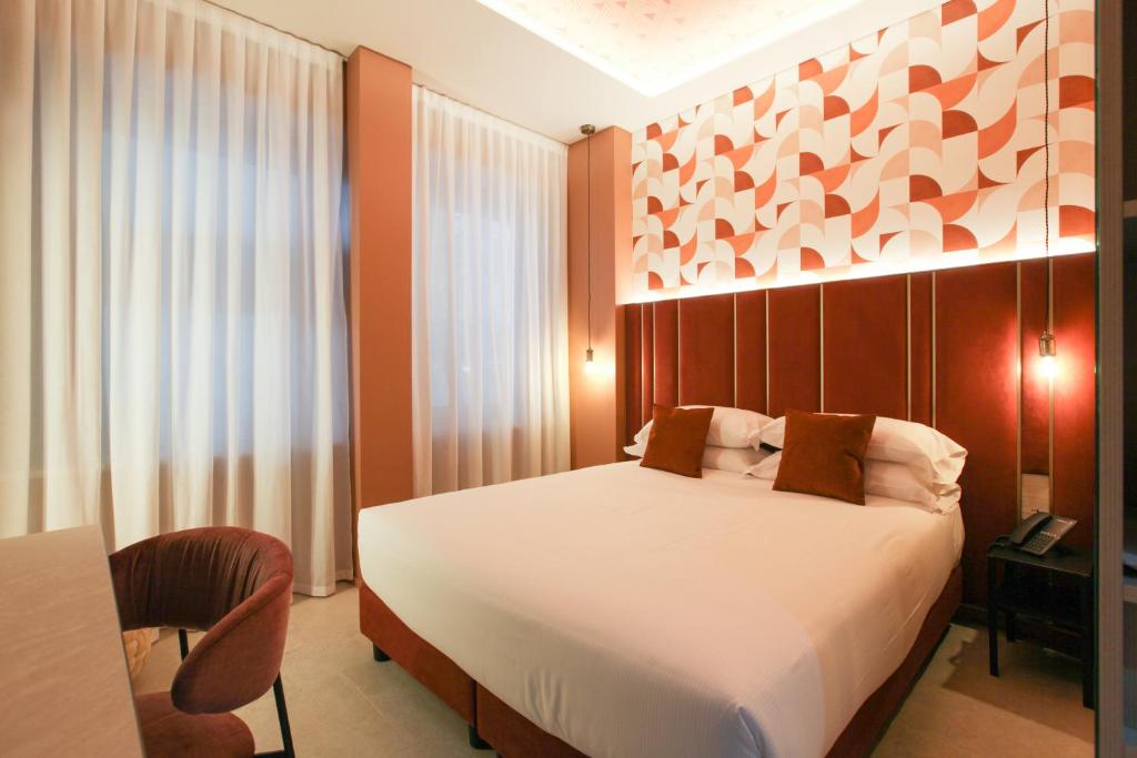 a bedroom with a bed and a desk and a chair at TheROOMS by TheFLOOR Collection in Milan