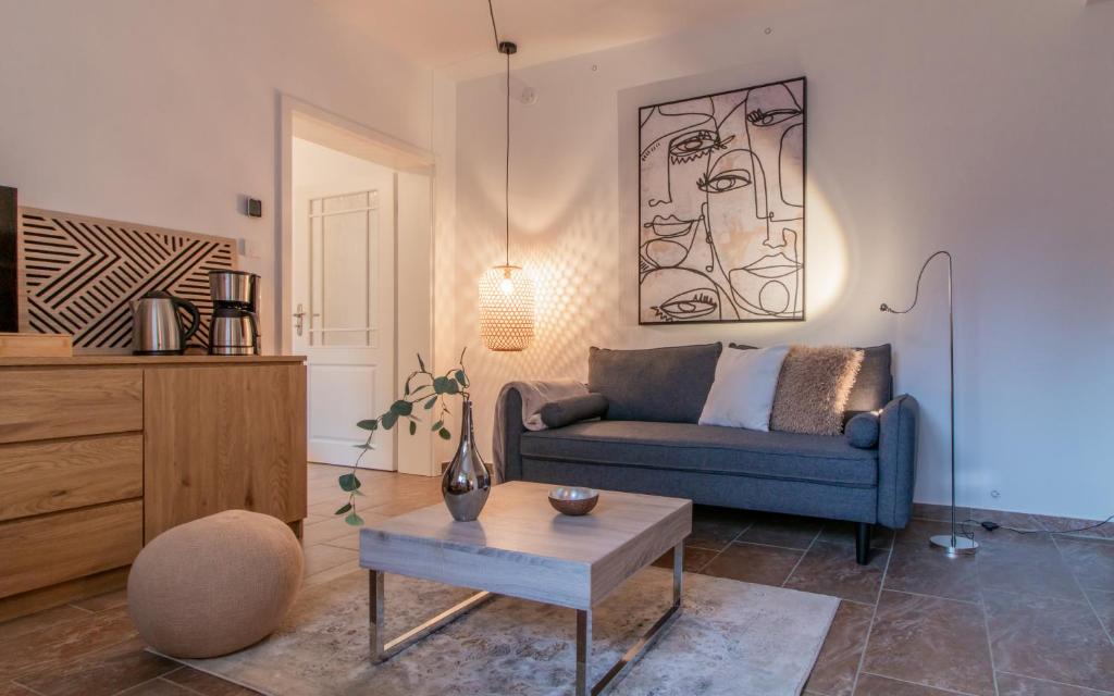 a living room with a blue couch and a table at Innenhof-Quartier in Meerane