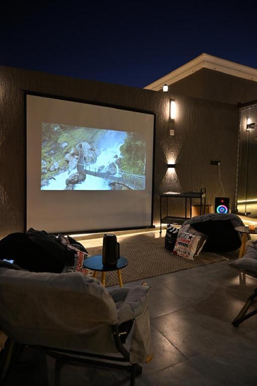a large projection screen in a room with chairs at شاليه لانتانا in Taif