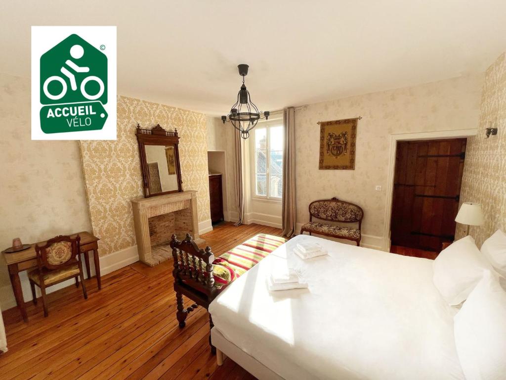 a living room with a bed and a fireplace at La Maison Voyage Bed and Breakfast in Onzain