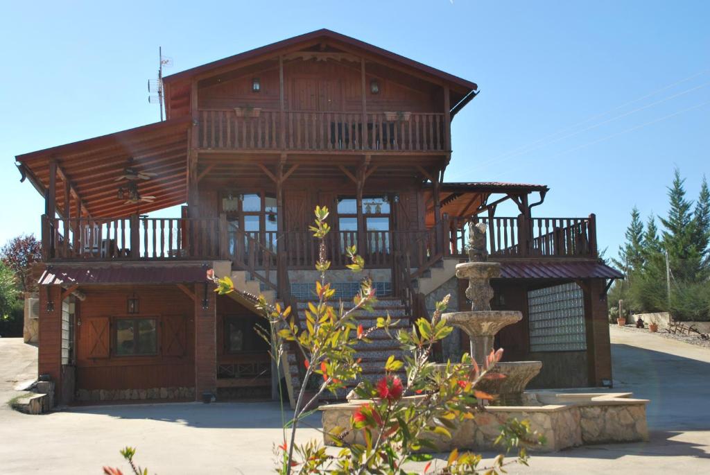a large wooden house with a fountain in front of it at Casa Telma in Alcañiz