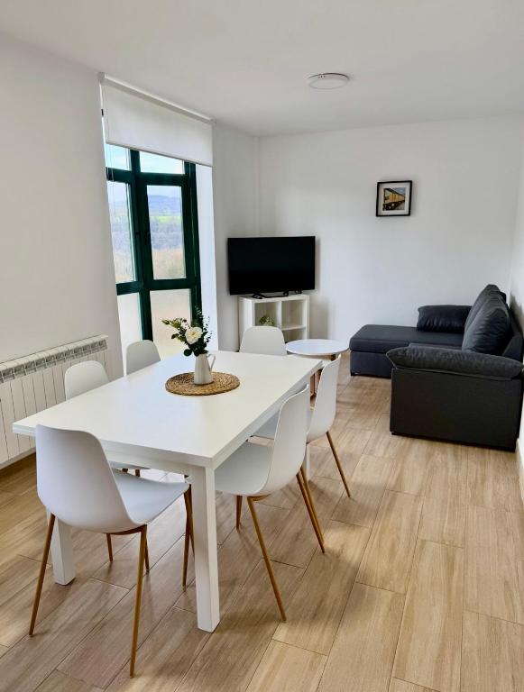 a living room with a white table and chairs at PortoHome 2 in Portomarin