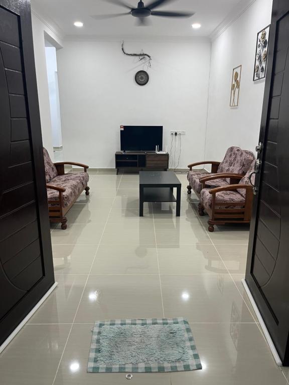 a living room with two couches and a tv at SaiMurni Homestay in Jerantut
