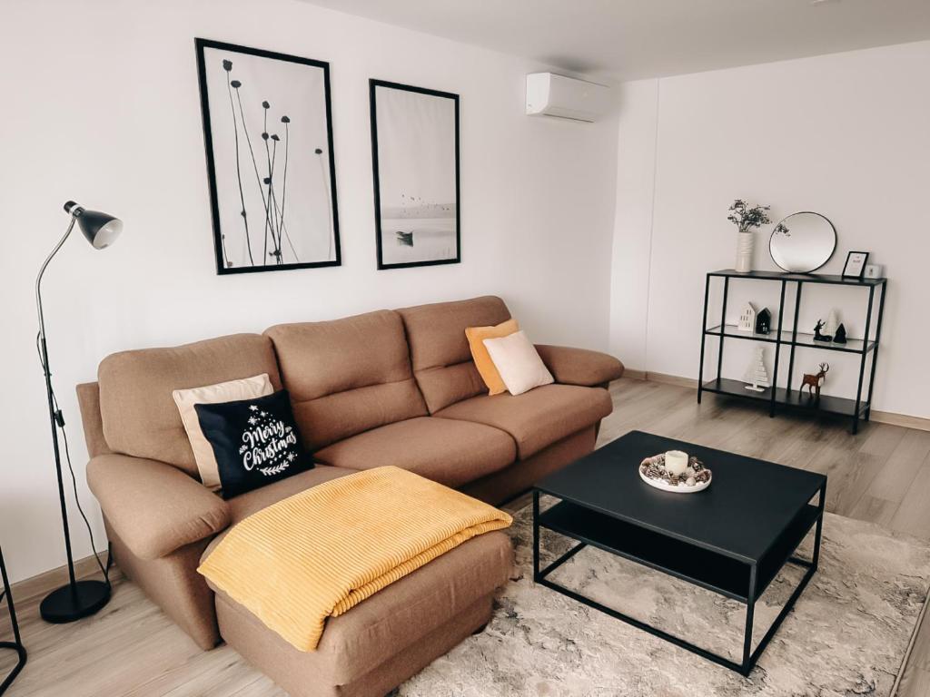a living room with a brown couch and a table at Apart 53 in Turda
