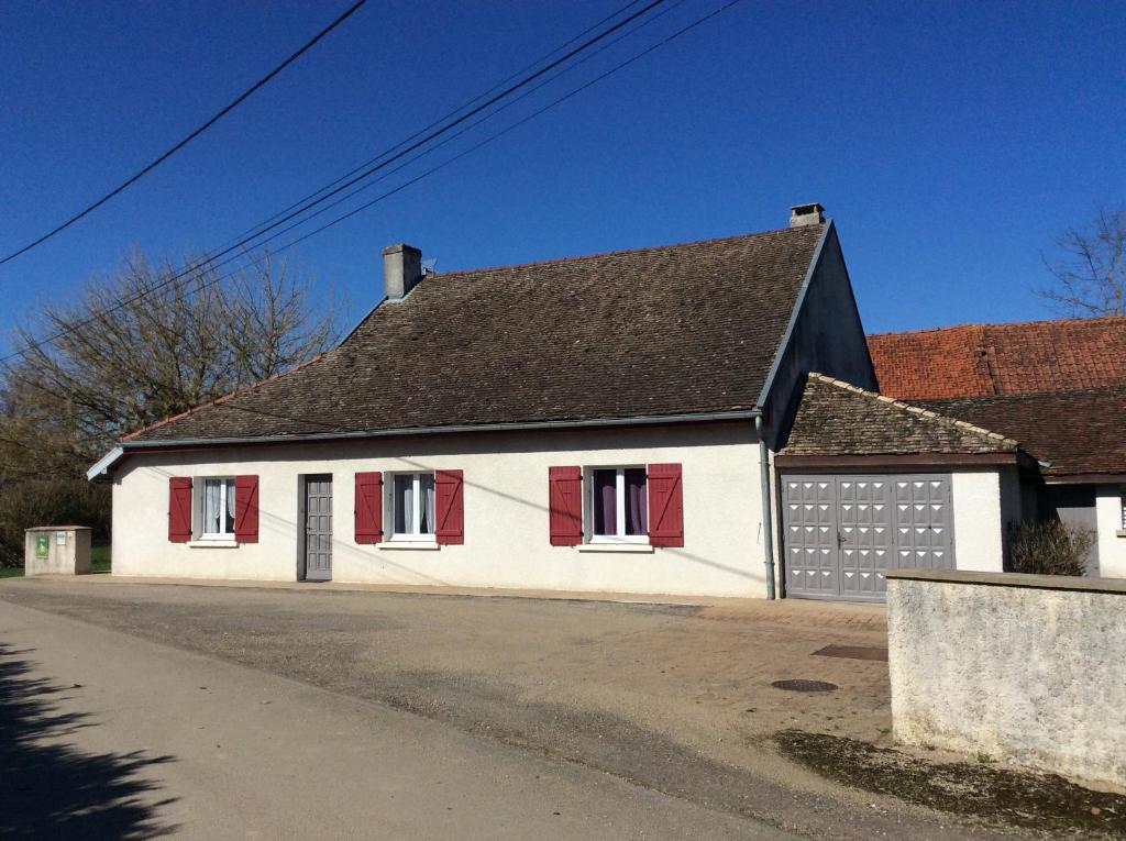 a white house with red shutters and a black roof at Le gîte a momo in Annoire