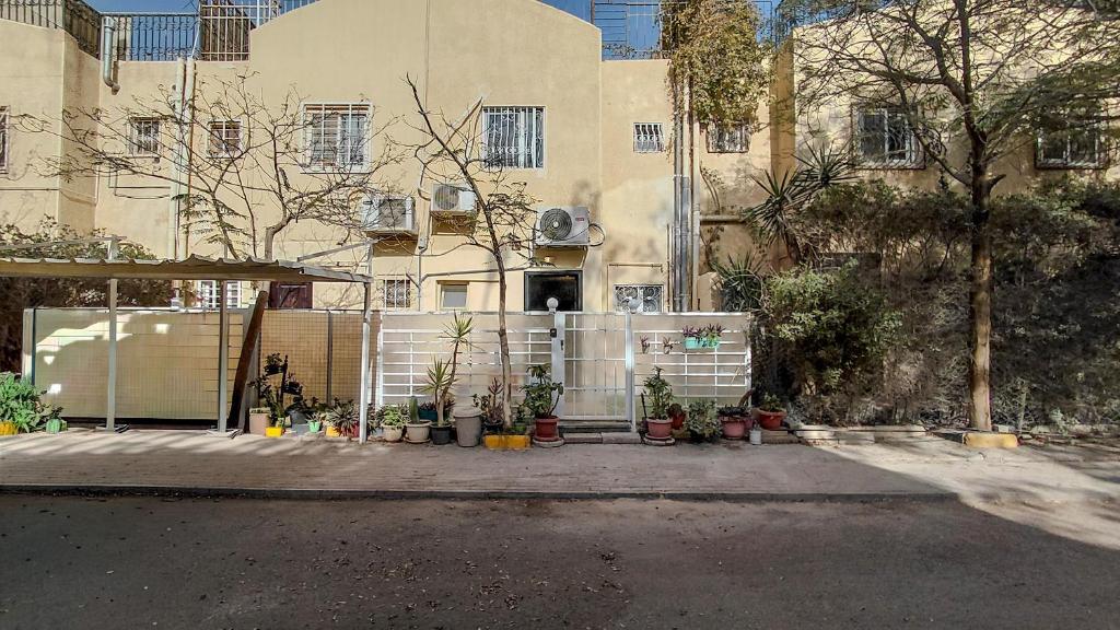 a building with a gate and plants in front of it at 325 · 2BR Townhouse 2 Bath TV in Sheikh Zayed