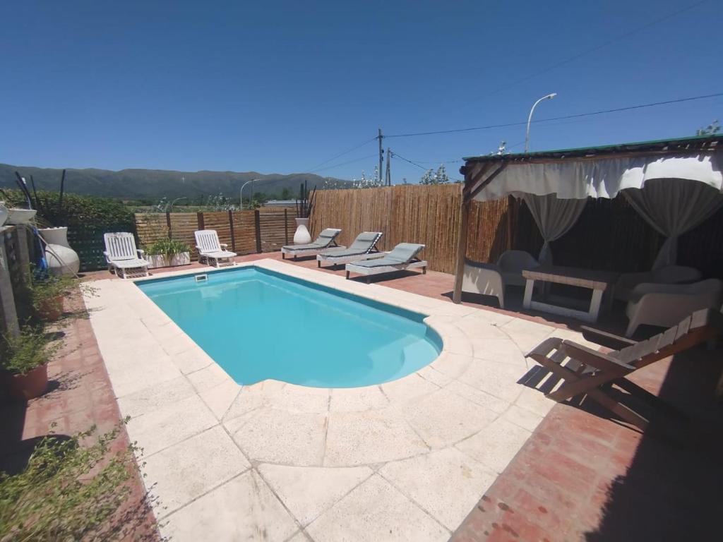 a swimming pool in a yard with chairs around it at miradas serranas 2 in Villa Giardino