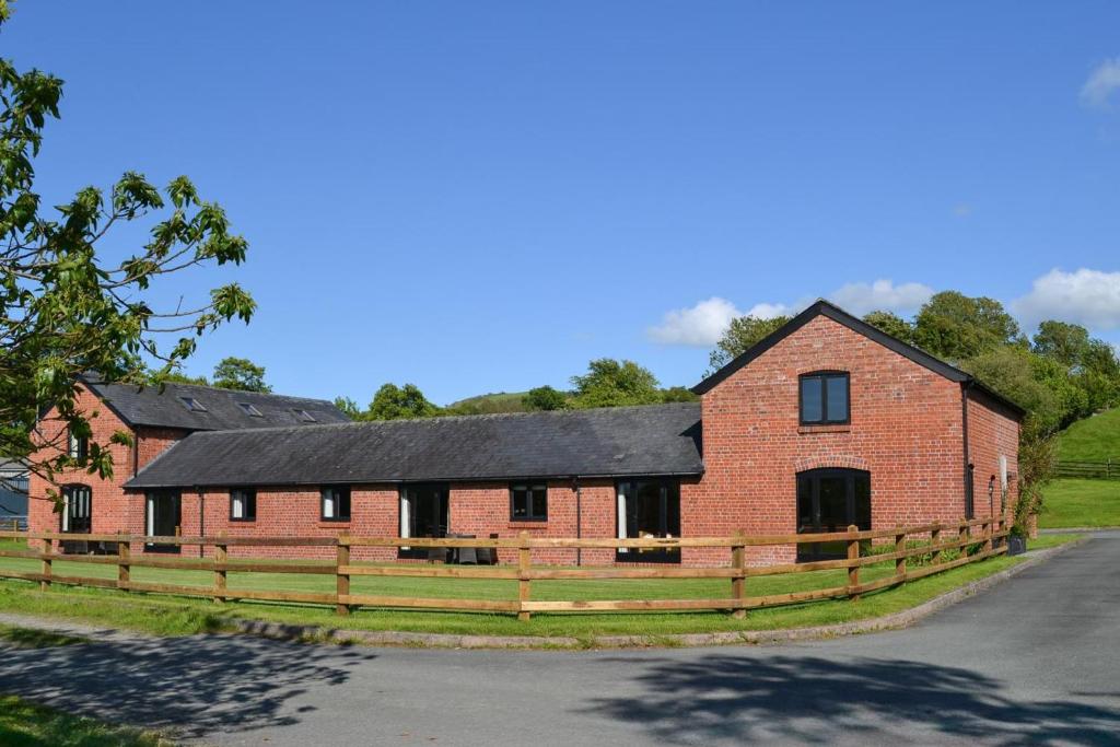 a large red brick building with a black roof at 2 Bed in Llandinam oc-waa377 in Llandinam
