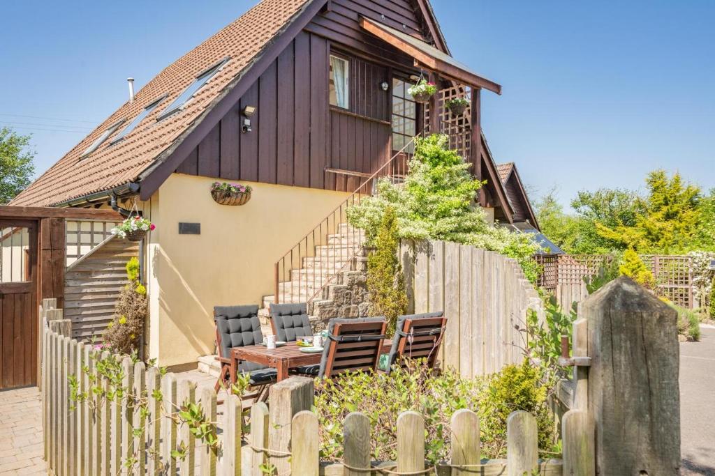 a wooden house with chairs and a wooden fence at 2 Bed in Shipham oc-s31934 in Shipham