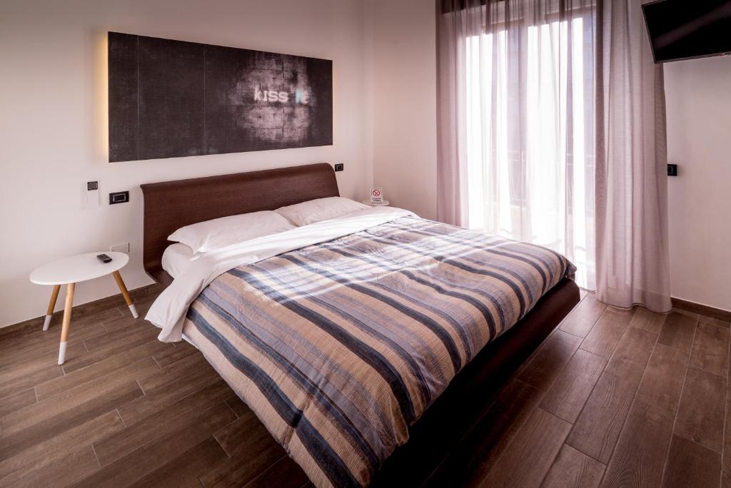 ファーノにあるAffittacamere "A2 PASSI"のベッドルーム1室(大型ベッド1台、ストライプ毛布付)