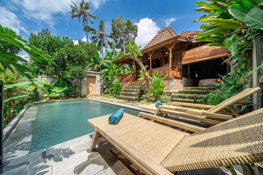 a villa with a swimming pool and a house at Saughina Ubud in Ubud