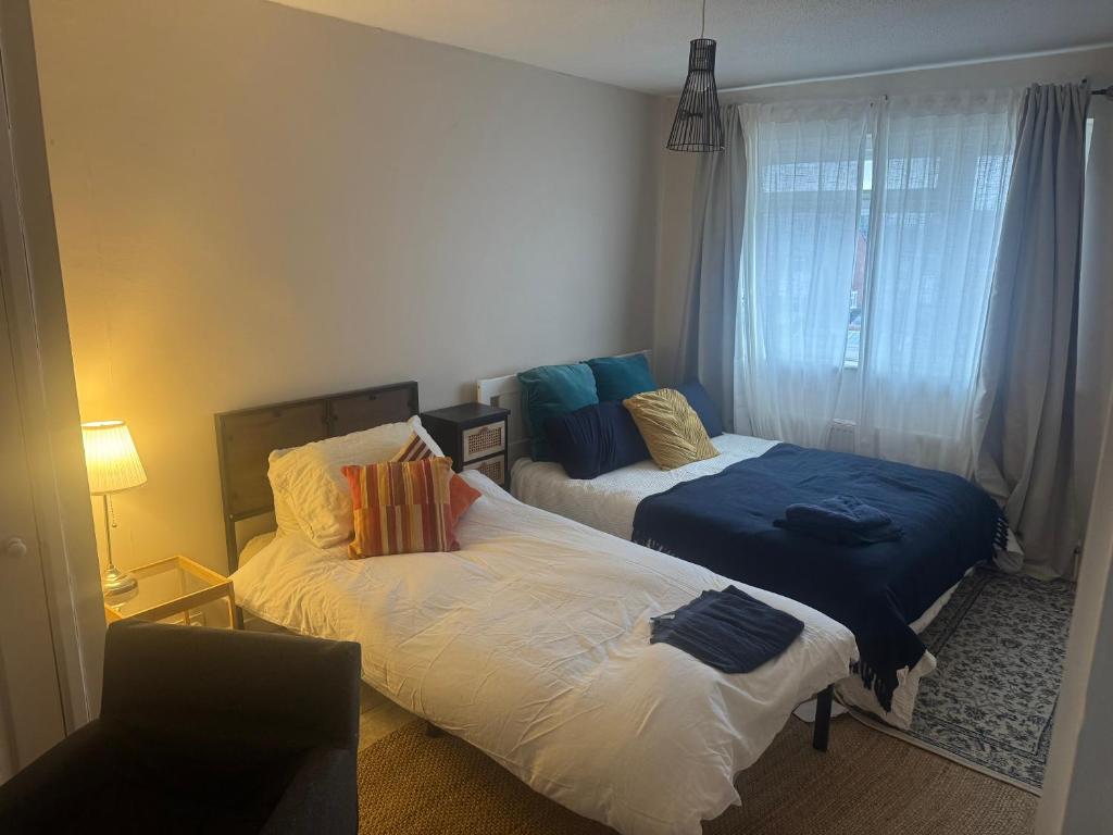 a bedroom with two beds and a window at Sunflower villa in Brislington