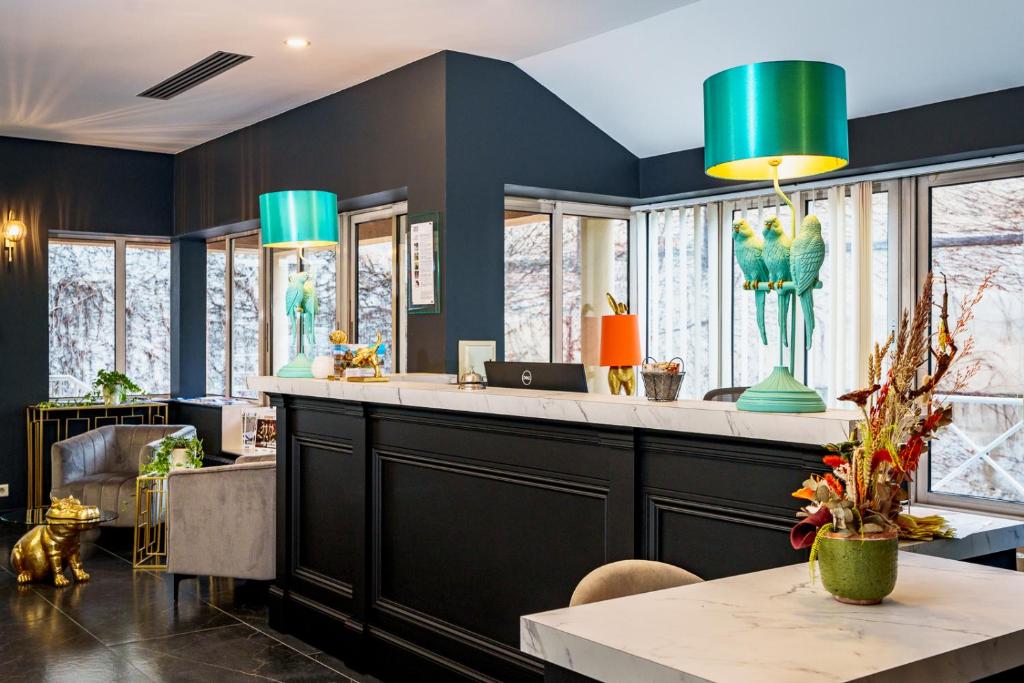 a lobby with blue walls and a counter with green lamps at Logis Hotel Le Parc in Moulins