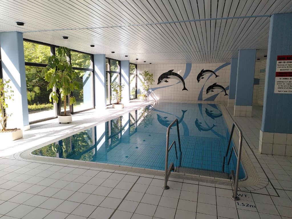 a swimming pool with dolphins painted on the wall at Refugium.311 in Bad Reichenhall