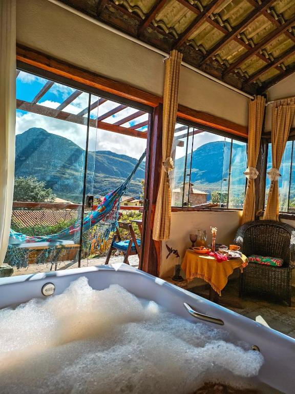 a bath tub in a room with a view at Chalé com Jacuzzi vista para Pico da Lapinha in Santana do Riacho