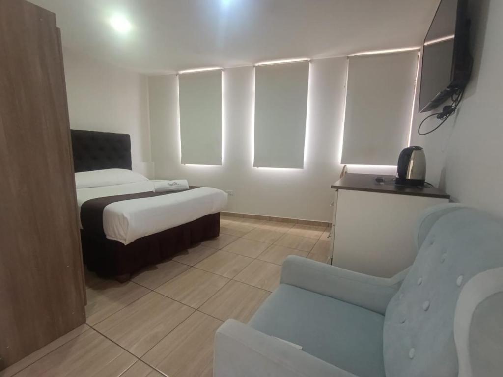 a bedroom with a bed and a chair and a couch at Hotel Cortaderas Arequipa in Yanahuara