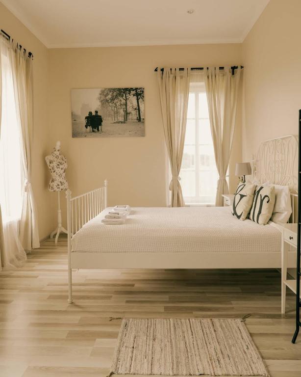 a bedroom with a white bed and a window at Kambarys prie vynuogyno in Pikeliškės