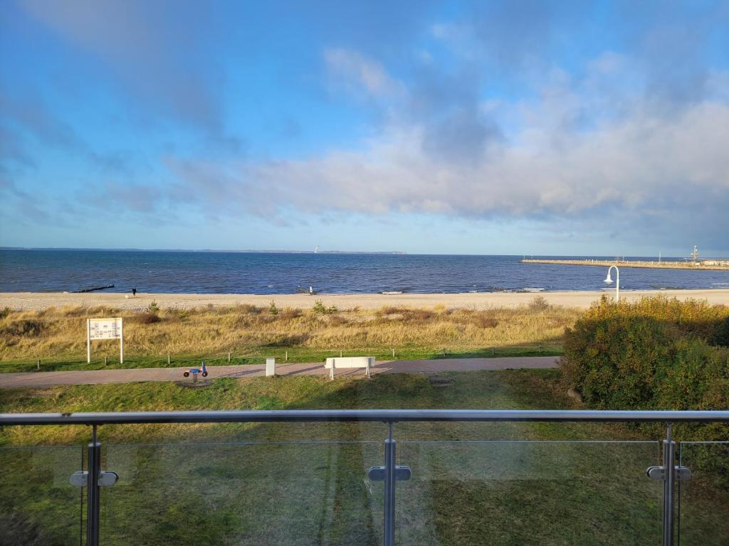 a view of a beach and the ocean from a balcony at Strandvilla GLOWE - Strandjuwel in Glowe