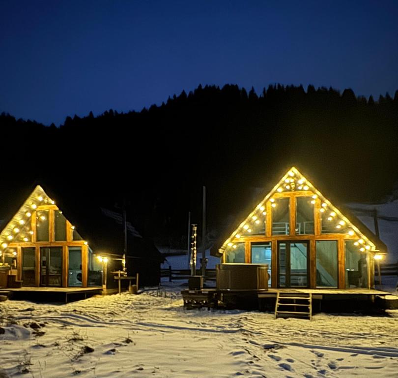 a house with lights on it in the snow at Dukaty House 2 in Verkhovyna