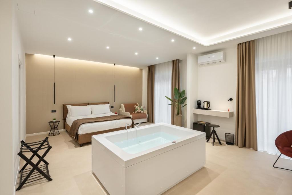 a bathroom with a bath tub and a bed at Cali Luxury Suites in Caserta