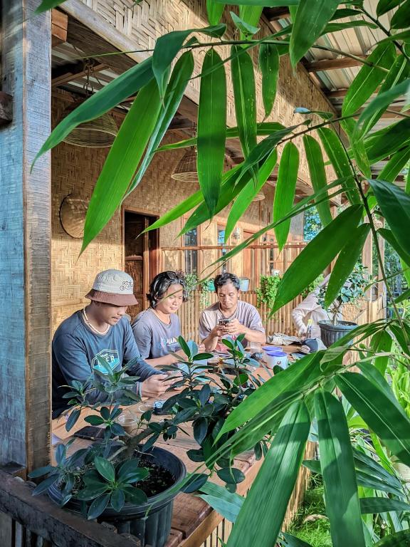 a group of people sitting around a table with plants at Local Garden Homestay in Masbagik
