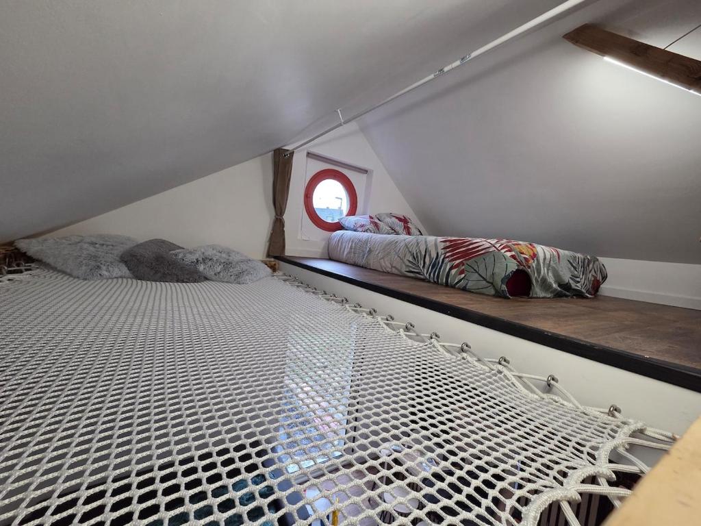 a small room with two beds and a window at la cabane de la régalante in Rannée