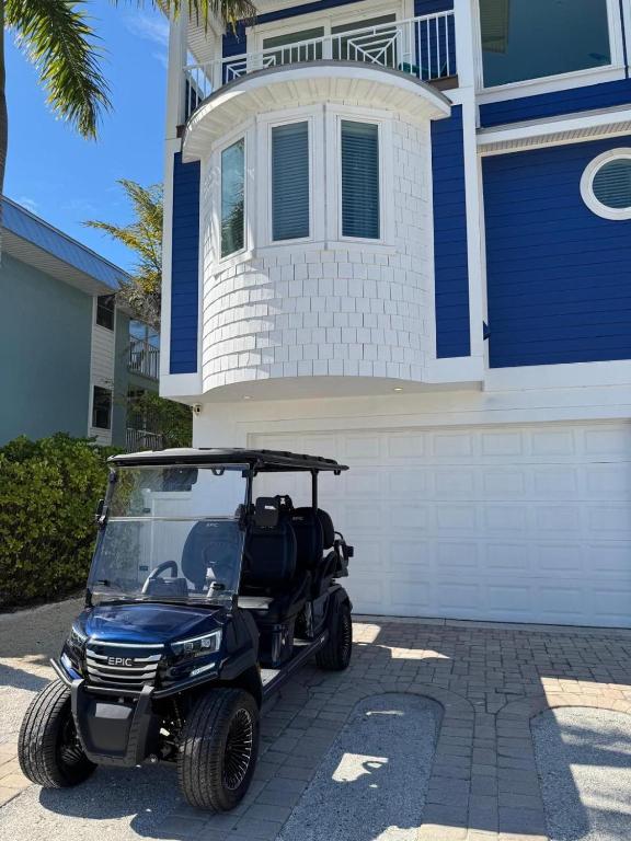 a golf cart parked in front of a house at LUXURY VACATION HOME! ADD A GOLF CART!! in Bradenton Beach