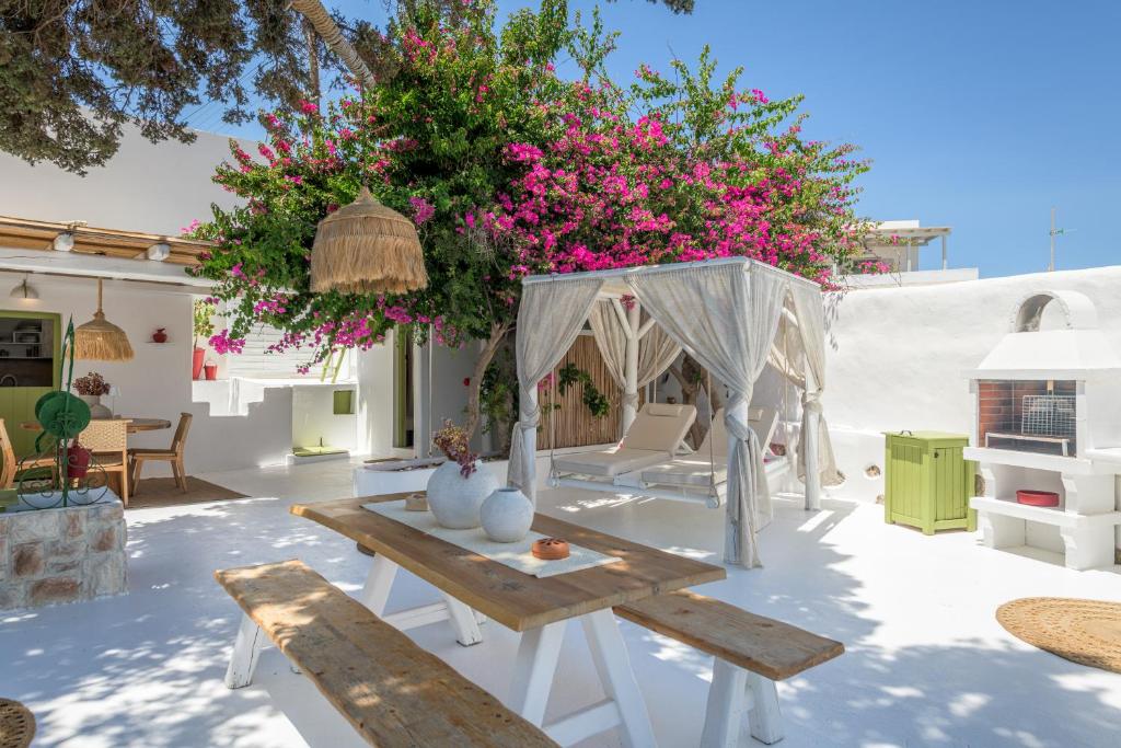 a patio with a table and benches and pink flowers at Villa Lord in Pollonia