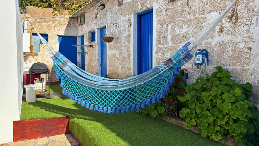 a blue hammock hanging outside of a house at MarketHome Ecolodge Plataneras 2 in Chío