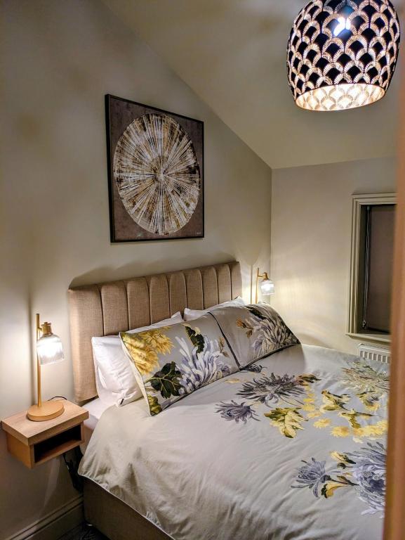 a bedroom with a bed and a chandelier at Pudsey Loft Apartment in Pudsey