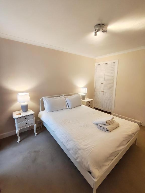 a bedroom with a large white bed with two lamps at Fintry Inn in Fintry