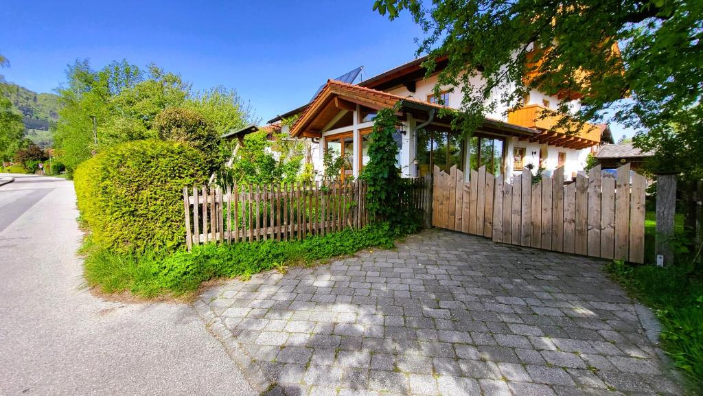 a house with a wooden fence next to a driveway at Ferienwohnungen Hörterer | Chiemgau Karte in Grassau