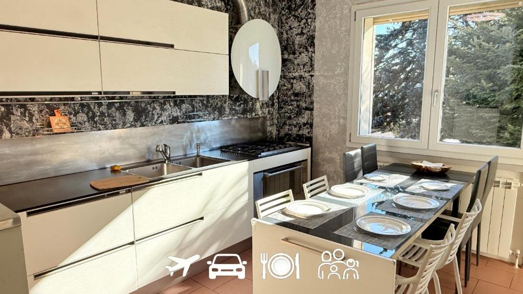 a kitchen with a table with chairs and a sink at Family 3-Bedroom Apartment near MXP & Lake Maggiore - Parking in Sesto Calende