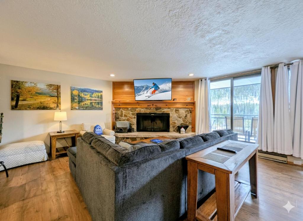 a living room with a large couch and a fireplace at Montezuma 1770 by SummitCove Lodging in Colorado in Keystone