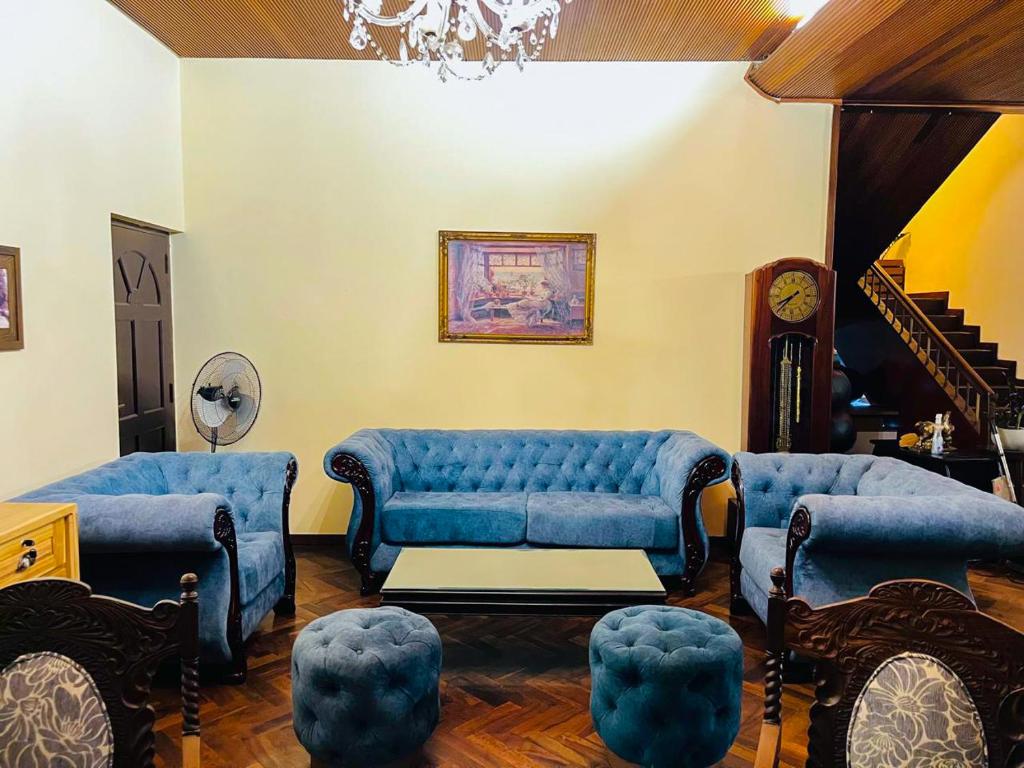 a living room with two blue couches and a table at Bungalow 36 in Kandy