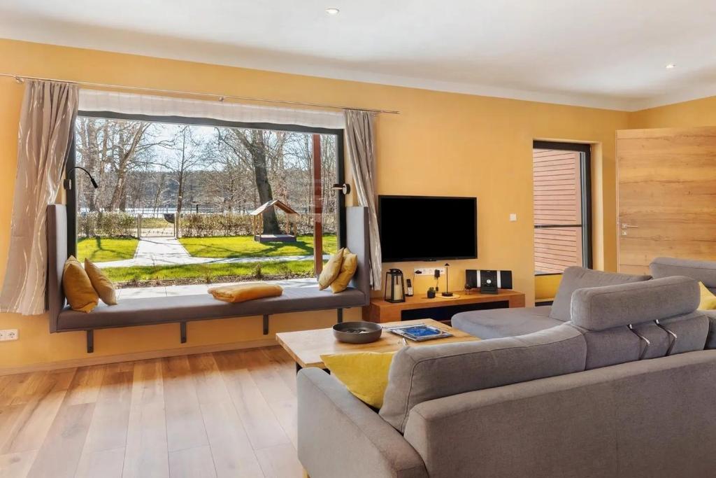 a living room with a couch and a large window at Ferienhaus Mond mit Sternenblick in Lochow