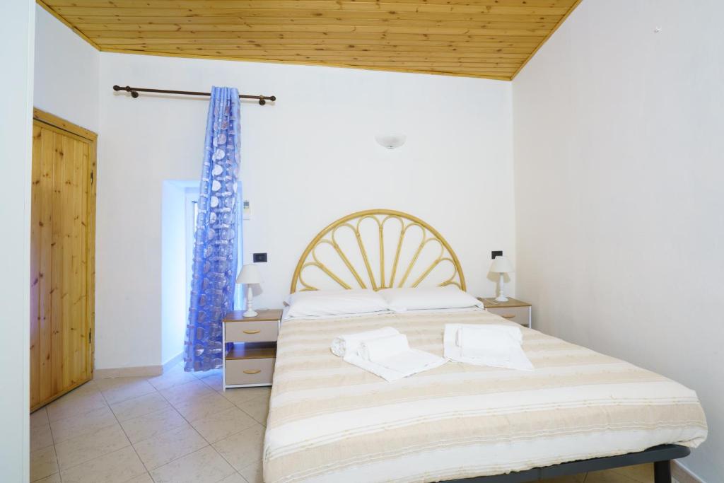 a bedroom with a large bed and a wooden ceiling at CaTorre 14 in Riomaggiore