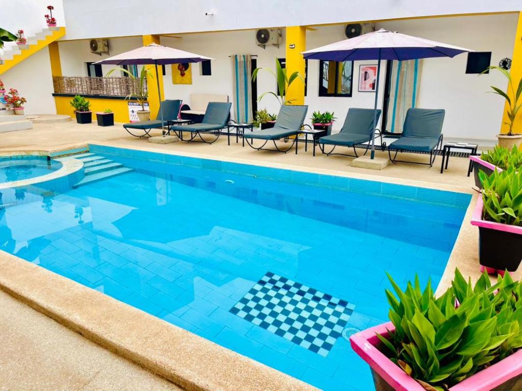 a pool with chairs and umbrellas at a hotel at La Brise de Ngaparou in Ngaparou