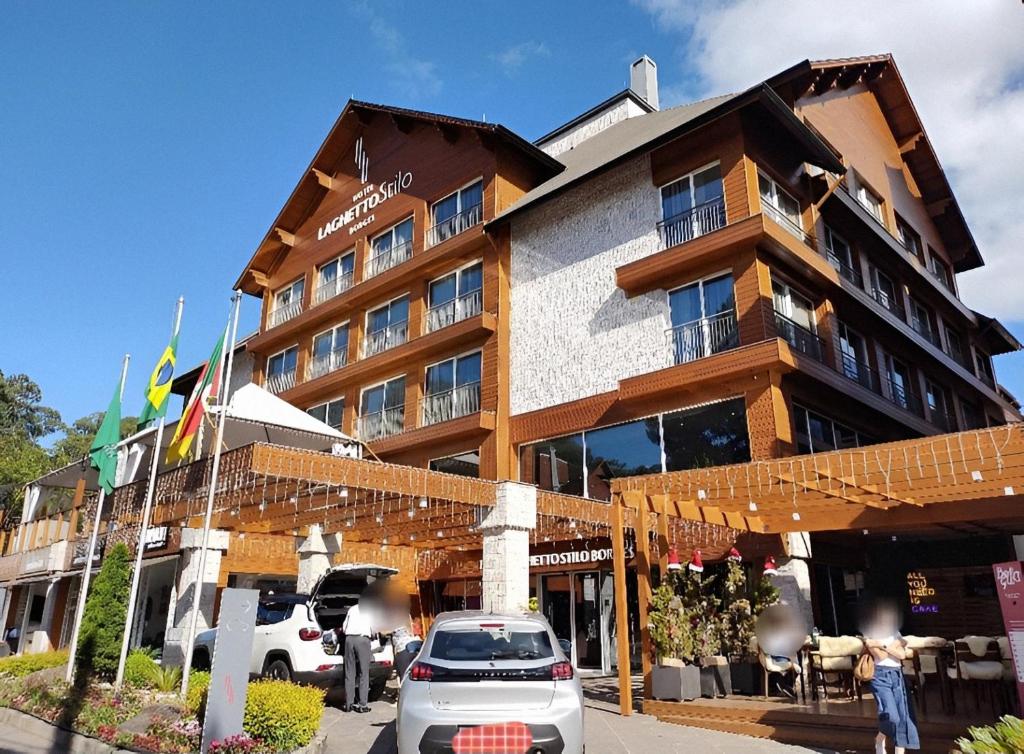 a hotel with cars parked in front of it at Laghetto Stilo Borges - Apto 403B in Gramado