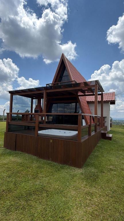 a large house with a large deck with a large window at Chalé Pôr do Sol Contenda in Contenda