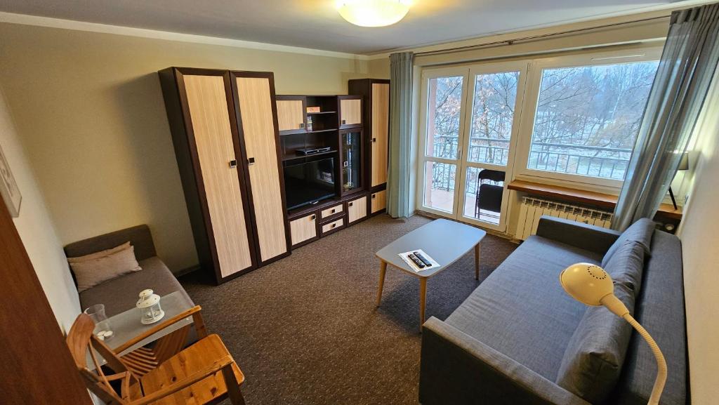 a living room with a couch and a tv at Apartament RSL in Ruda Śląska